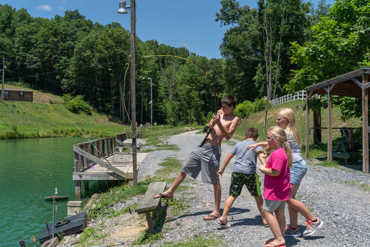 Tristan "Turtle" Hylton of Beckley, West Virginia, reels in his line at Brandy's Catfish and Trout Pond while Leah J. King, Jayden Farnsworth and Uriah Farnsworth await what they hope is a big catch.