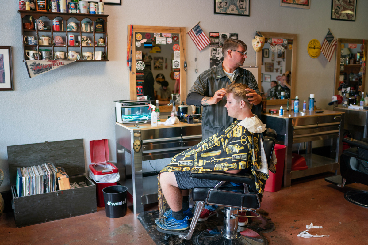 Jason Kovach gives Brandon Fisher, 15, a trim at Tonic Room Barber Shop in London, Kentucky. "America is badass," he said. (Tilly Martlatt/News21)