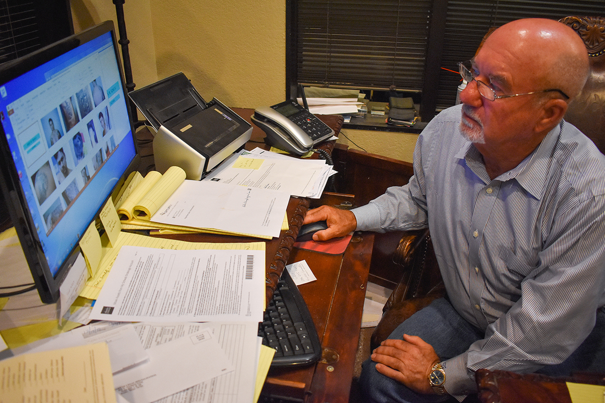 Former Jasper County prosecutor Guy James Gray looks through 20-year-old evidence photos from the James Byrd Jr. murder case. (Lillianna Byington/News21)