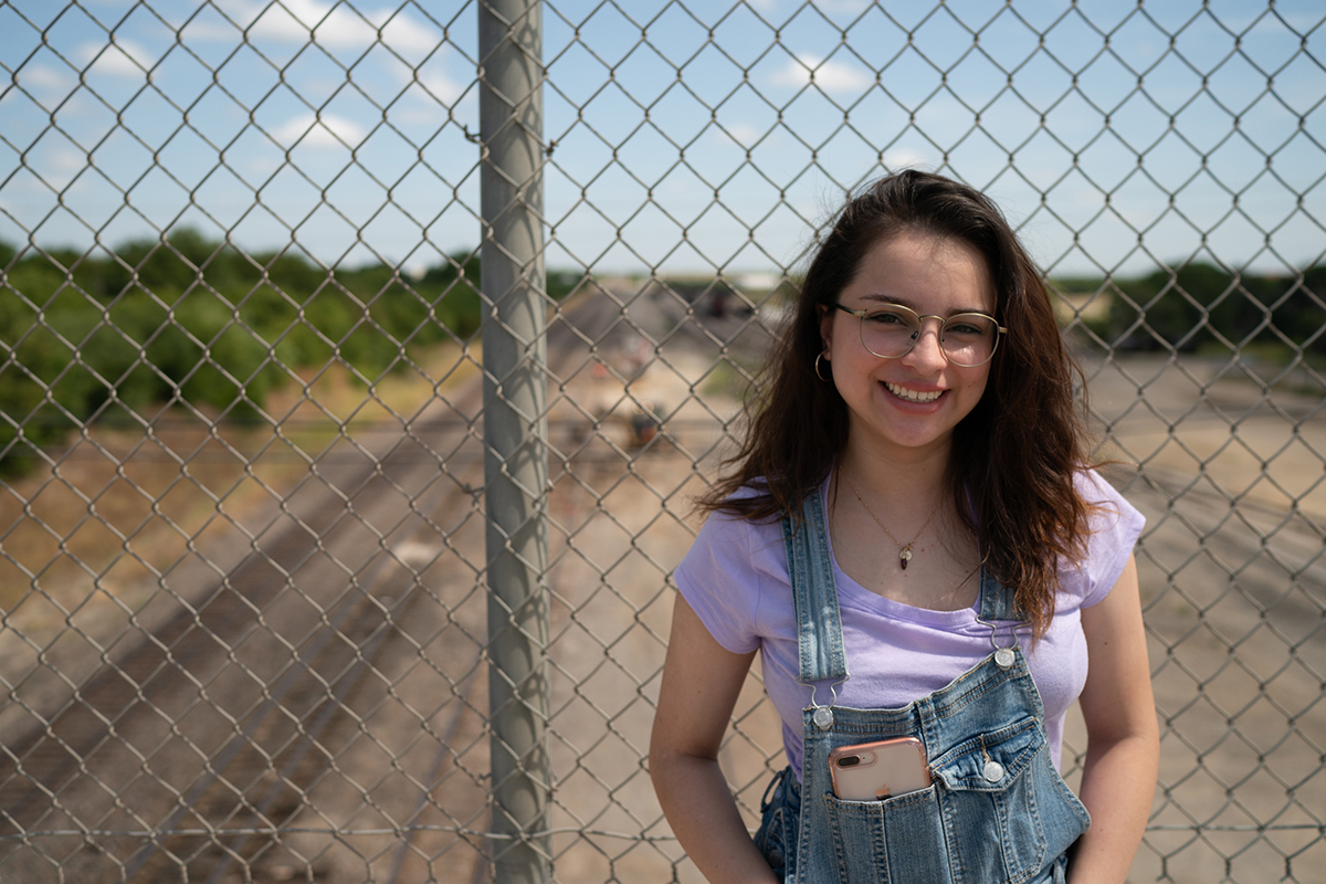 Pricila Garcia, 20, stands on a bridge overlooking train tracks in Cleburne, Texas. Garcia, the daughter of Mexican immigrants, said the tracks symbolize the deep socioeconomic divide in Cleburne. (Angel Mendoza/News21)