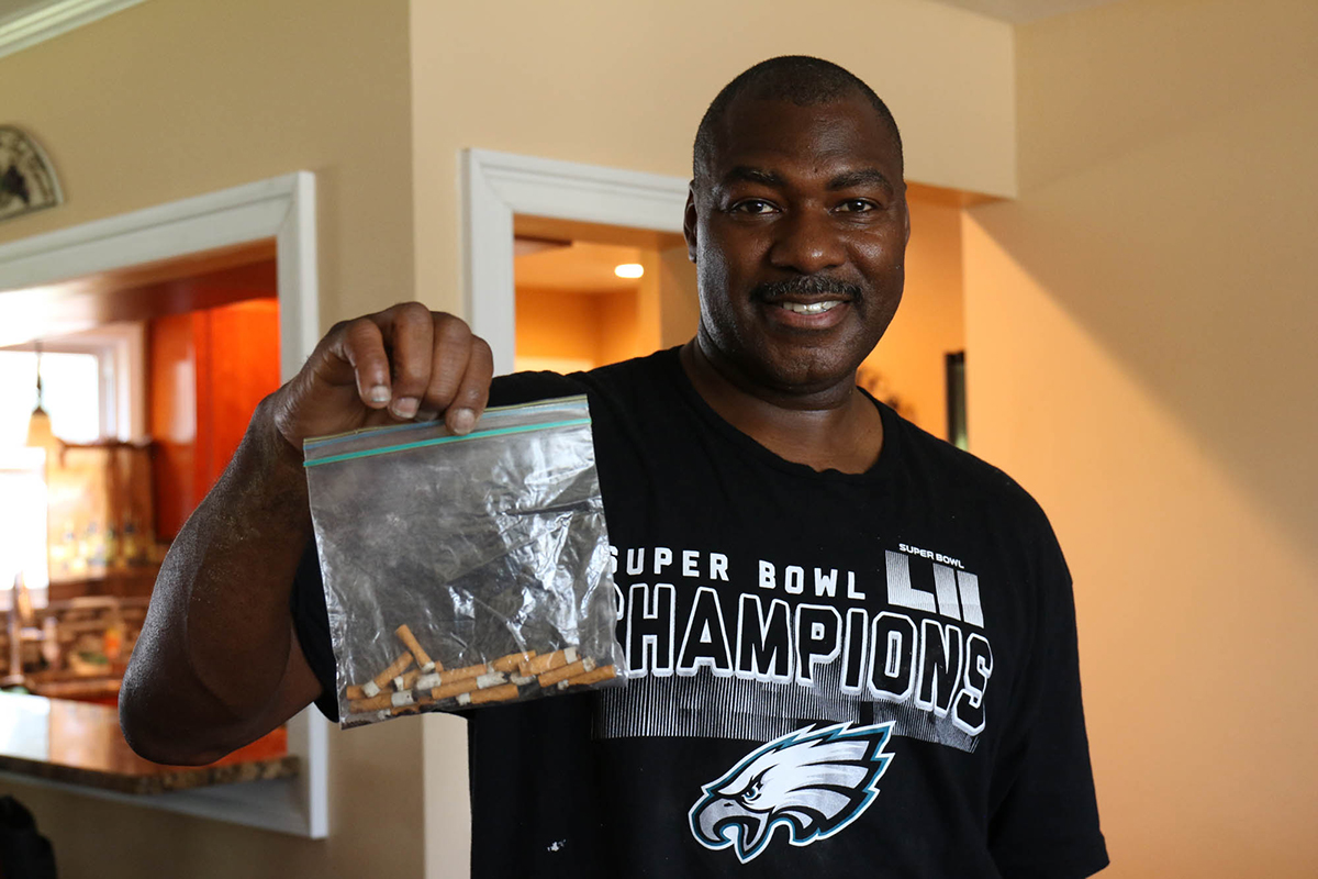 Antonio Baker holds a bag a cigarette butts that his neighbor, Robert Kujawa, left on their doorstep in Bethlehem Township, Pennsylvania. Baker said he kept the butts in case he and his wife needed to produce evidence in court one day. (Jimmie Jackson/News21)