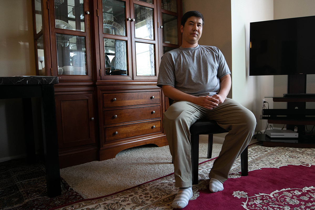 Fawad Mohammadi, an Afghan immigrant who worked as an interpreter for the U.S. military, sits in the living room of his home near Portland, Oregon. Mohammadi lost his right leg below the knee after he was rammed by a vehicle in what prosecutors call a hate crime. (Scott Bourque/News21)